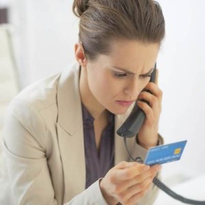 Business Woman With Credit Card Talking Phone In Office